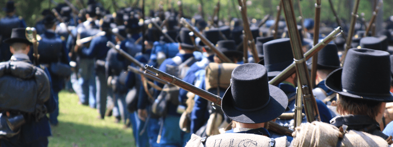 A formation of men in military uniforms, armed with guns, demonstrating a strong and organized presence.