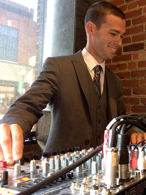 a man standing near a brick wall
